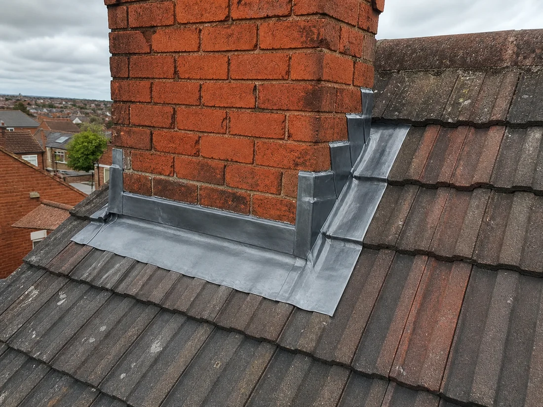New lead flashing around a chimney on a tiled UK roof